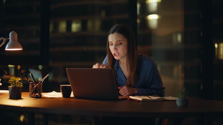 Woman yelling at laptop late at night - Overtime Violations